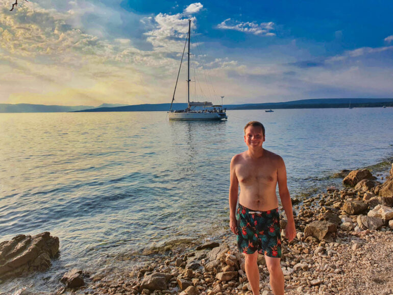 Steven in front of a boat at the sea