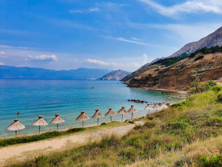 Umbrellas along the shore on Vela Plaža Baška beach our best beach in Croatia